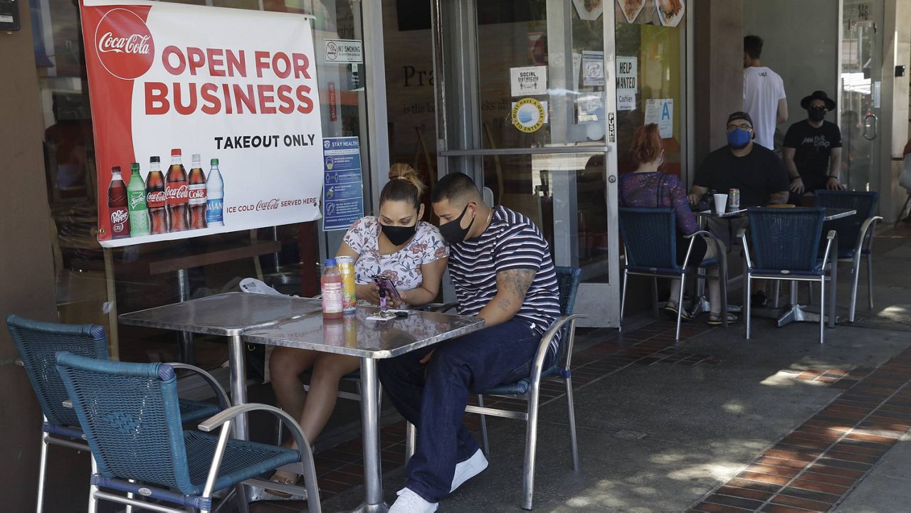 In this July 18, 2020, file photo, Josefina Pacheco, front left, and her husband Norberto wait to have a meal served outside at a restaurant in Burbank, Calif. (AP Photo/Marcio Jose Sanchez, File)