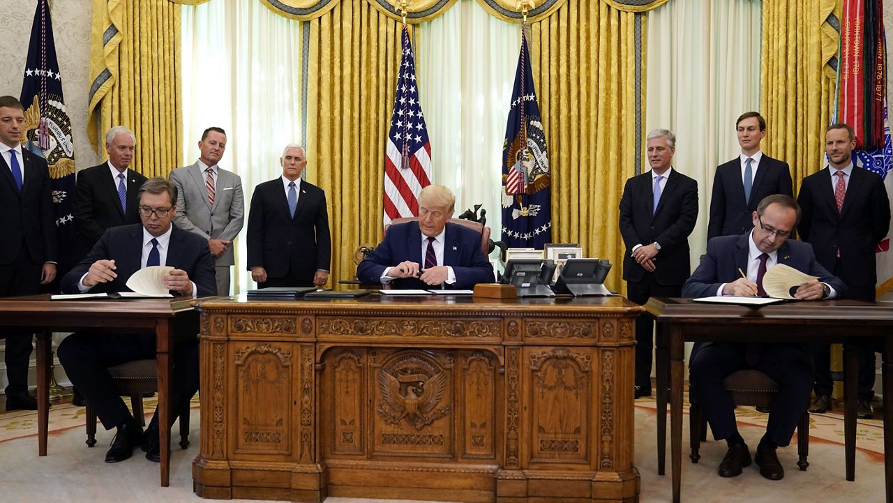 President Donald Trump participates in a signing ceremony with Serbian President Aleksandar Vucic, seated left, and Kosovar Prime Minister Avdullah Hoti, seated right, in the Oval Office of the White House, Friday, Sept. 4, 2020, in Washington. (AP Photo/Evan Vucci)