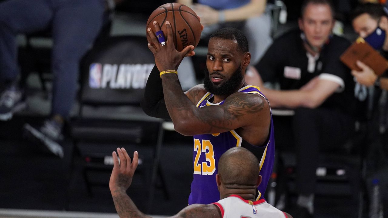 Los Angeles Lakers' LeBron James (23) looks to pass over Houston Rockets' P.J. Tucker (17) during the second half of an NBA conference semifinal playoff basketball game Friday, Sept. 4, 2020, in Lake Buena Vista, Fla. (AP Photo/Mark J. Terrill)