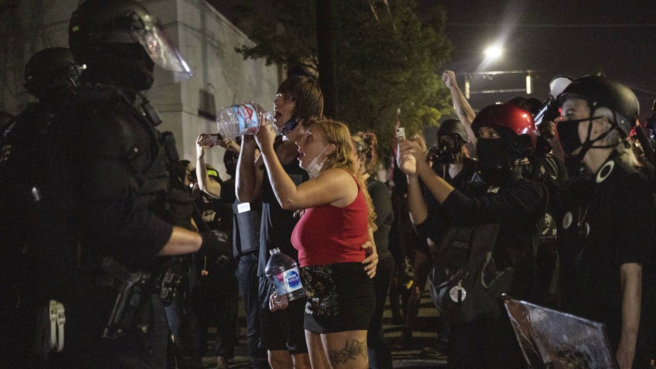 Protesters standoff with police as they take to the streets Friday, Sept. 4, 2020 in Portland, Ore. (AP Photo/Paula Bronstein)