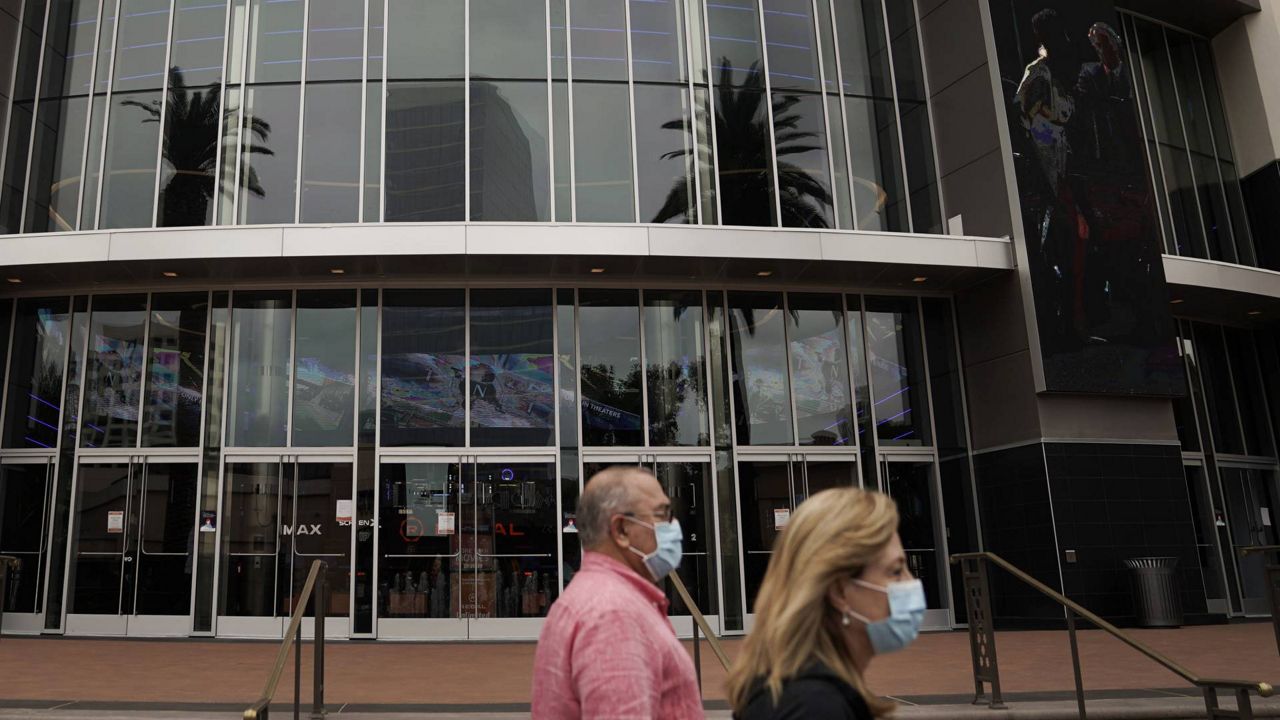Two shoppers walk past a Regal movie theater in Irvine, Calif., Tuesday, Sept. 8, 2020. (AP Photo/Jae C. Hong)
