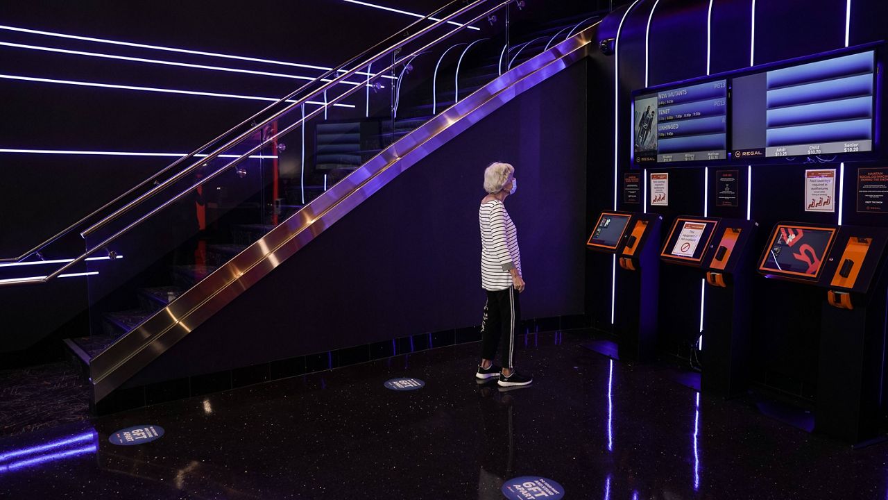 Karen Speros, 82, looks at showtimes to purchase a movie ticket at a Regal move theater in Irvine, Calif., Tuesday, Sept. 8, 2020.