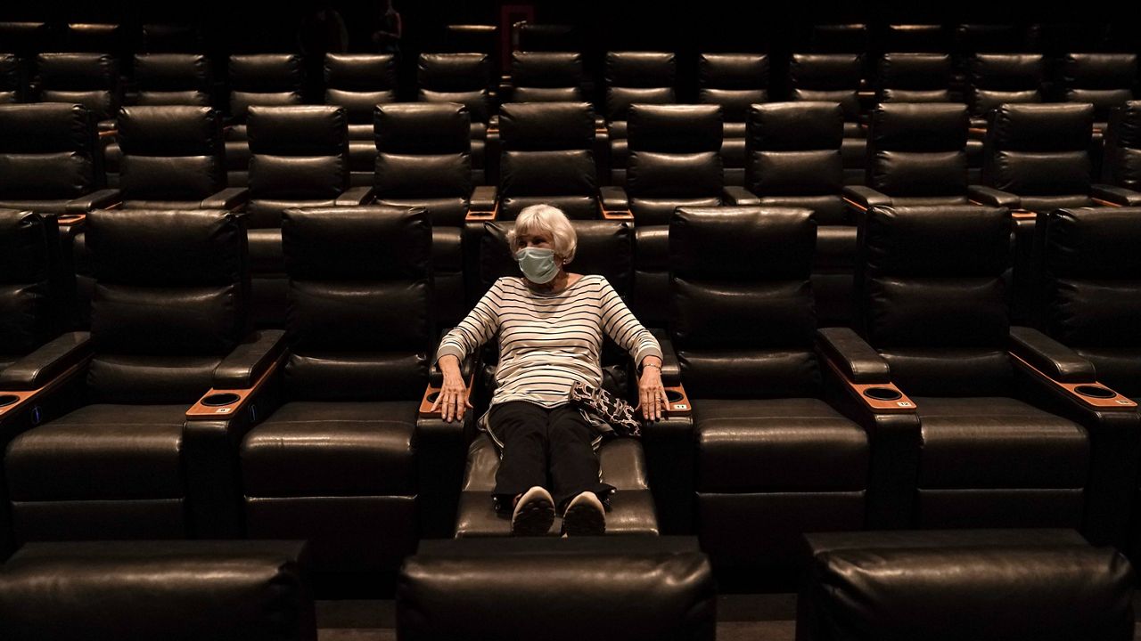 Karen Speros, 82, waits for a movie to start at a Regal movie theater in Irvine, Calif., Tuesday, Sept. 8, 2020. (AP Photo/Jae C. Hong)