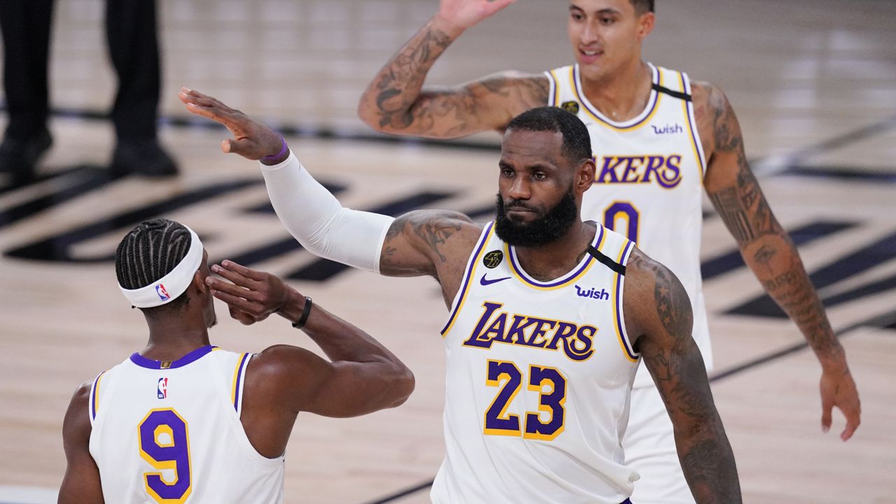 Los Angeles Lakers' LeBron James, Kyle Kuzma, rear, and Rajon Rondo (9) celebrate during the second half of an NBA conference semifinal playoff basketball game against the Houston Rockets Tuesday, Sept. 8, 2020, in Lake Buena Vista, Fla. (AP Photo/Mark J. Terrill)