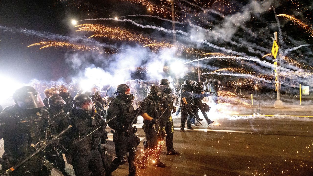 Police use chemical irritants and crowd control munitions to disperse protesters during a demonstration in Portland, Ore., Saturday, Sept. 5, 2020. (AP Photo/Noah Berger)