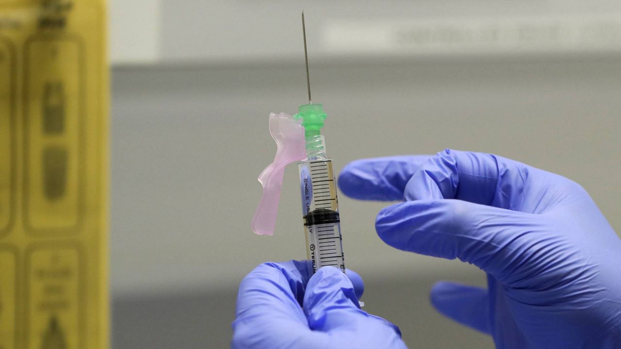 In this Aug. 5, 2020 photo, a senior clinical research nurse prepares the COVID-19 vaccine to administer to a volunteer at a clinic in London. (AP/Kirsty Wigglesworth)