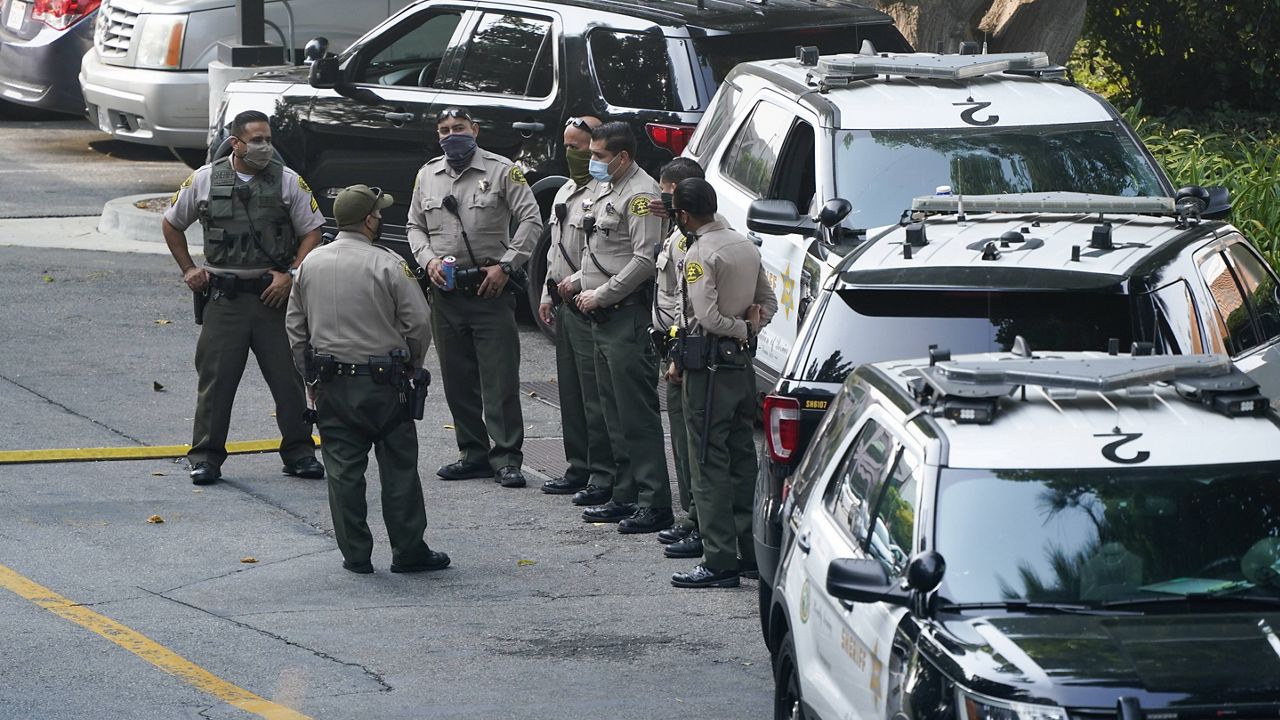 Police officers stand outside St. Francis Medical Center on Monday, Sept. 14, 2020, in Lynwood, Calif. Two Los Angeles County Sheriff's deputies were shot in an apparent ambush Saturday. (AP Photo/Ashley Landis)