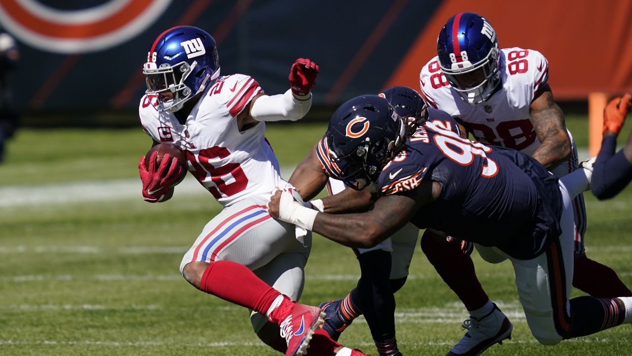 New York Giants running back Saquon Barkley (26) tries to break free from Chicago Bears defensive tackle John Jenkins (90) during the first half of an NFL football game in Chicago, Sunday, Sept. 20, 2020. (AP Photo/Charles Rex Arbogast)