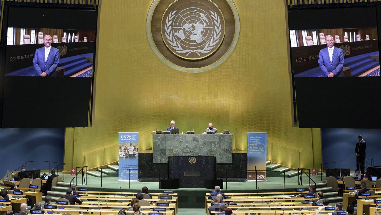 President of the International Court of Justice, Judge Abdulqawi Ahmed Yusuf, is seen on screens as he addresses the United Nations General Assembly. (Manuel Elías/United Nations via AP)