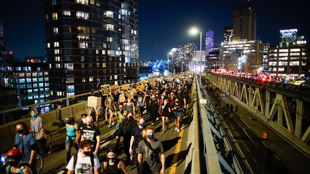 Protesters march across the Manhattan Bridge, Wednesday, Sept. 23, 2020, in New York, following a Kentucky grand jury's decision not to indict any police officers for the killing of Breonna Taylor. (AP Photo/Eduardo Munoz Alvarez)
