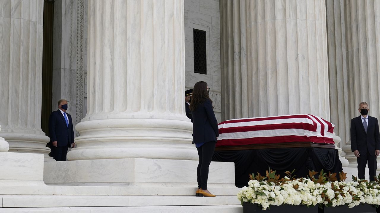 President Donald Trump, left, pays respects as Justice Ruth Bader Ginsburg lies in repose under the Portico at the top of the front steps of the U.S. Supreme Court building on Thursday, Sept. 24 2020, in Washington. Ginsburg, 87, died of cancer on Sept. 18. (AP Photo/Alex Brandon, Pool)