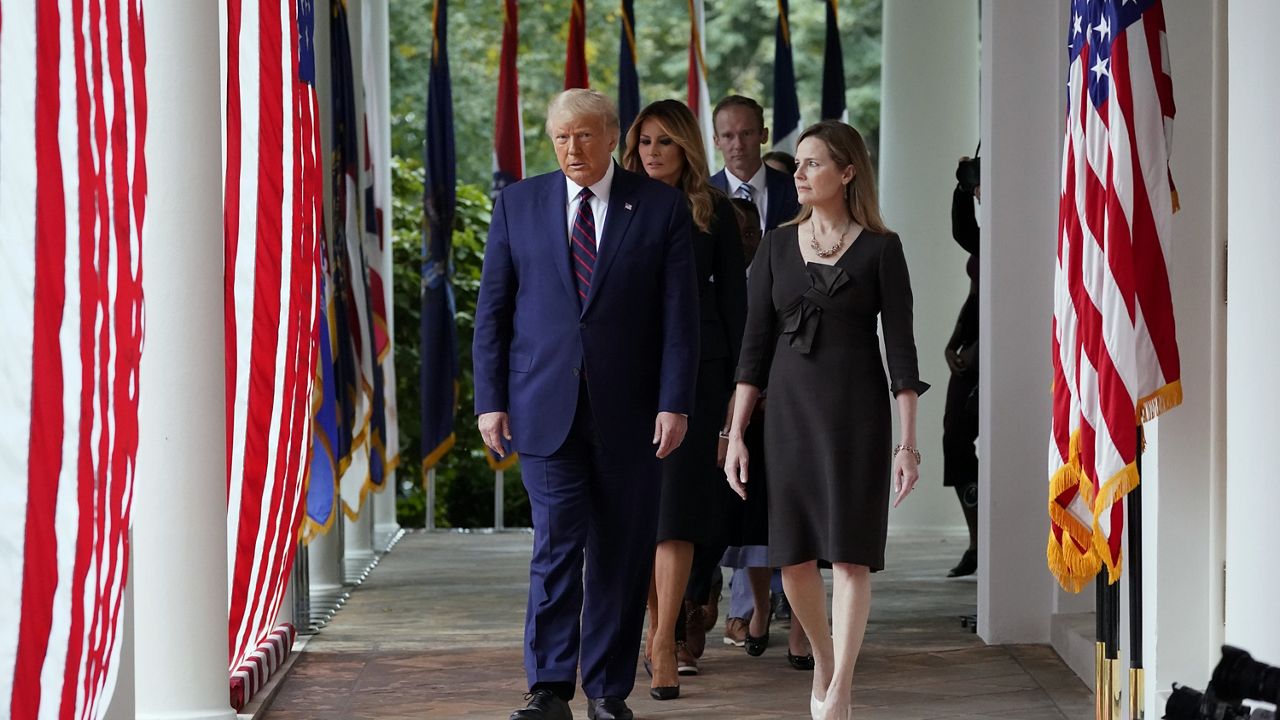 President Donald Trump walks along the Colonnade with Judge Amy Coney Barrett to a news conference to announce Barrett as his nominee to the Supreme Court, in the Rose Garden at the White House, Saturday, Sept. 26, 2020, in Washington. (AP Photo/Alex Brandon)