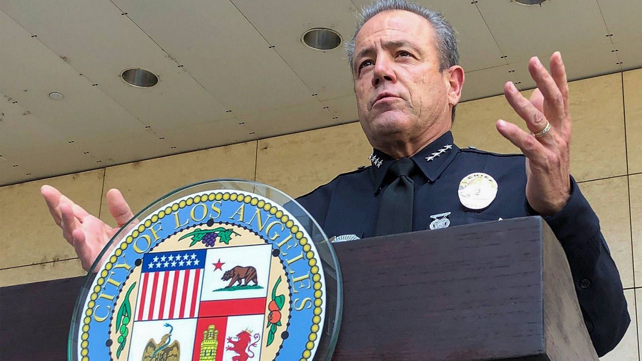Los Angeles Police Chief Michel Moore peaks outside the LAPD headquarters on Aug. 26, 2020. (AP Photo/Stefanie Dazio)