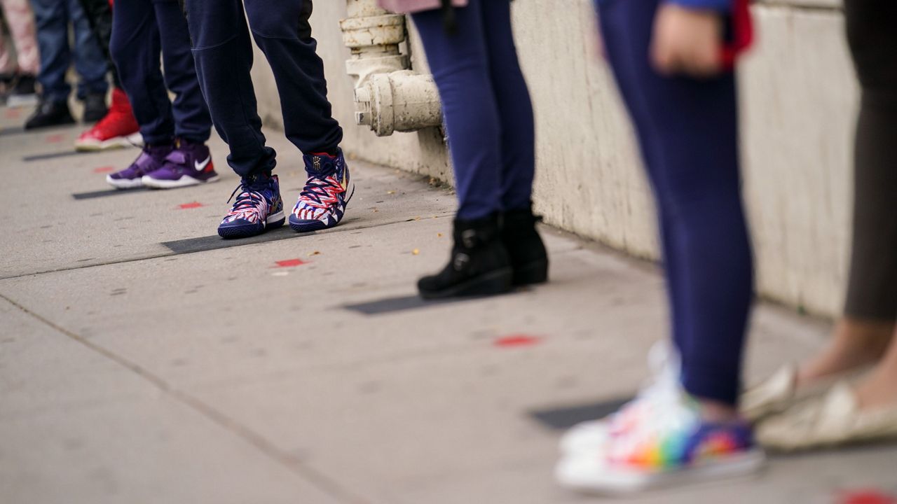 Students wait at socially distanced intervals as they arrive for in-person classes outside Public School 188 The Island School on Tuesday, Sept. 29, 2020.