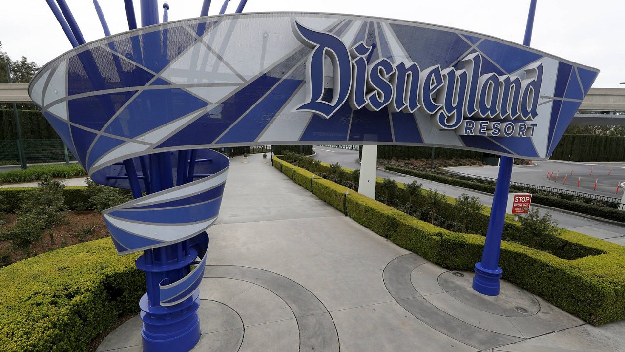 In this file photo taken Wednesday, March 18, 2020, one of the normally bustling entrances to the Disneyland resort is vacant due to the coronavirus closure in Anaheim, Calif. (AP Photo/Chris Carlson, File)