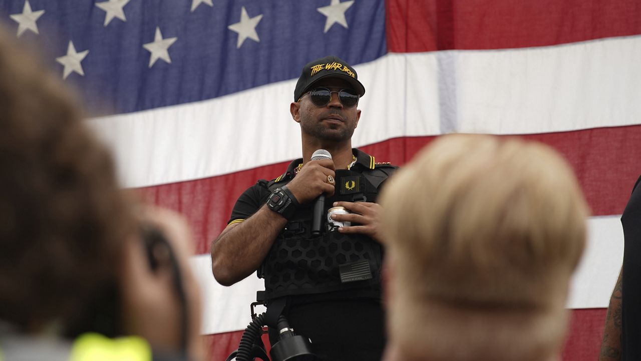 FILE - Proud Boys leader Enrique Tarrio wears a hat that says The War Boys and smokes a cigarette at a rally in Delta Park on Sept. 26, 2020, in Portland, Ore. (AP Photo/Allison Dinner, File)