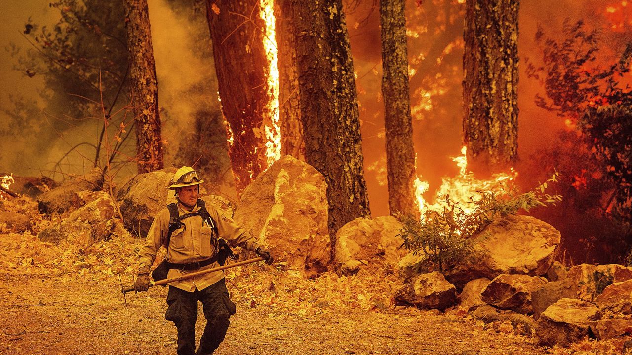 A firefighter walks a path as the Glass Fire burns along Highway 29 in Calistoga, Calif., on Thursday, Oct. 1, 2020. (AP Photo/Noah Berger)