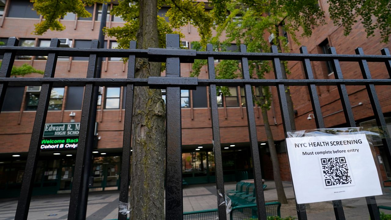 A sign posted on Oct. 2nd advises anyone entering Edward R. Murrow High School must go through a city health screening, Monday, Oct. 5, 2020, in the Midwood section of the Brooklyn borough of New York. The school is one of many in New York City that will close Tuesday after New York Gov Andrew Cuomo ordered schools in city neighborhoods with high coronavirus rates to shut down.