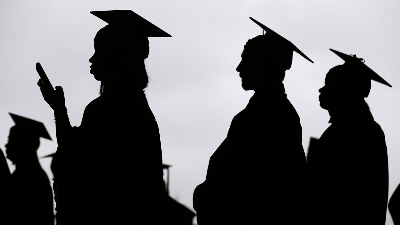 FILE - In this May 17, 2018, file photo, new graduates line up before the start of the Bergen Community College commencement at MetLife Stadium in East Rutherford, N.J. (AP Photo/Seth Wenig, File)