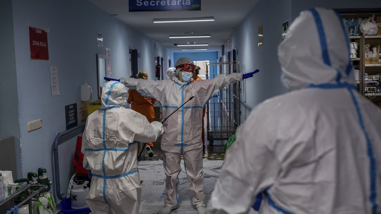 A medical team member is disinfected before leaving the COVID-19 ward at the Severo Ochoa hospital in Leganes, outskirts of Madrid, Spain, Friday, Oct. 9, 2020. (AP Photo/Bernat Armangue)