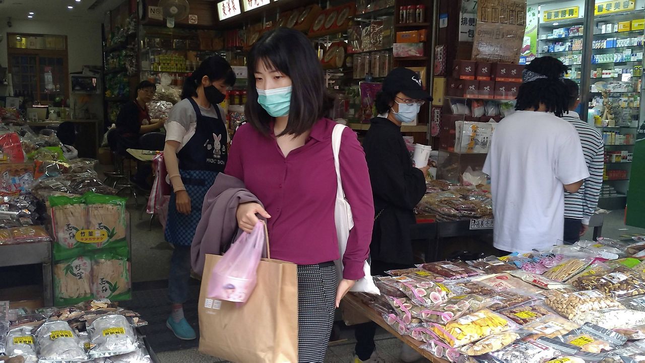 People wearing face masks to help curb the spread of the coronavirus shop at a market in Taipei, Taiwan, on Monday. (AP Photo/Chiang Ying-ying)