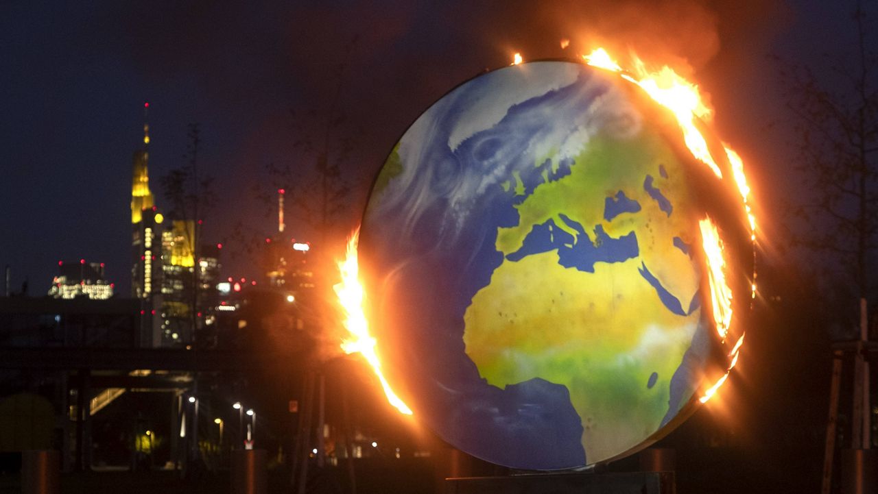 A makeshift globe burns in front of the European Central Bank in Frankfurt, Germany, on Oct. 21. (AP Photo/Michael Probst)