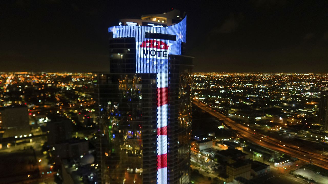 The 700-foot Paramount Miami Worldcenter skyscraper lights-up the city’s skyline with the nation’s largest electronic U.S. flag and gigantic L.E.D. “VOTE” button image. (Bryan Glazer/World Satellite Television News via AP Images)