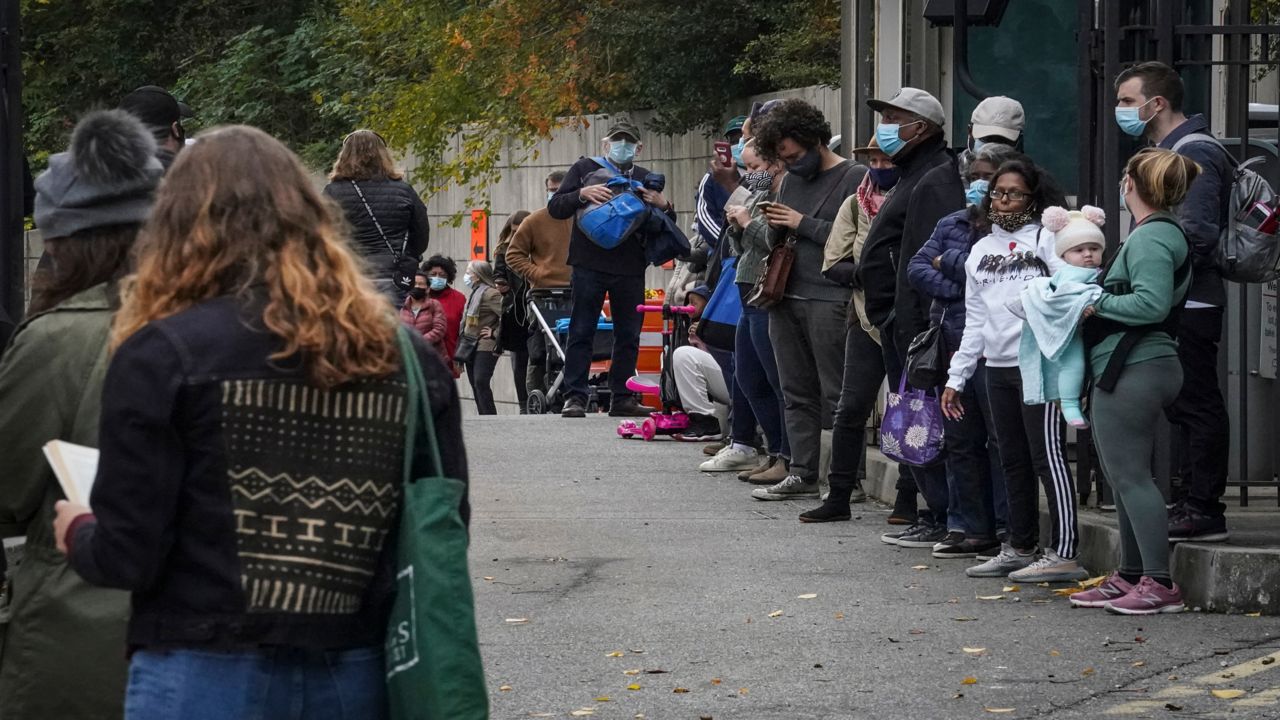 Voters wait in long lines before the polls open for early voting at the Brooklyn Museum, Tuesday Oct. 27, 2020, in New York. 