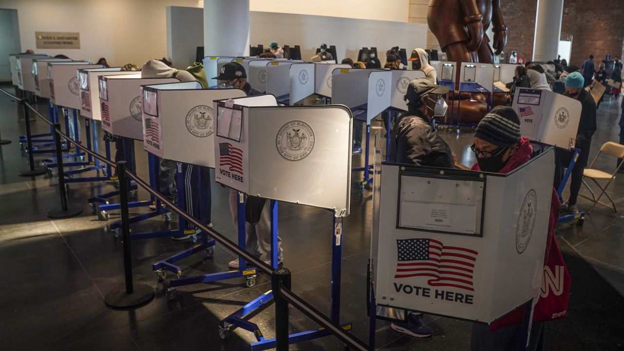 Voters cast their ballots at privacy booths during early voting at the Brooklyn Museum, Tuesday Oct. 27, 2020, in New York. (AP Photo/Bebeto Matthews)
