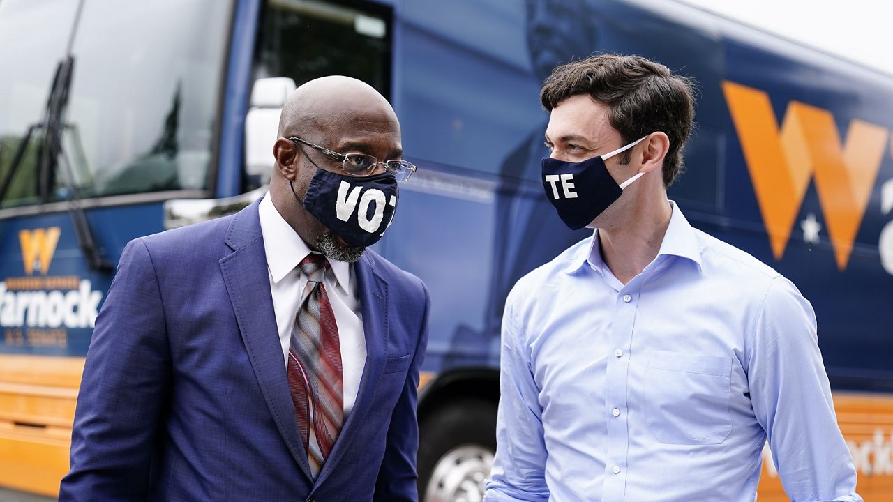 Democratic candidate for Senate Jon Ossoff, right, and Democratic candidate for Senate Raphael G Warnock, left, arrive before they speak to a crowd during a "Get Out the Early Vote" event at the SluttyVegan ATL restaurant on Tuesday, Oct. 27, 2020, in Jonesboro, Ga. (AP Photo/Brynn Anderson)