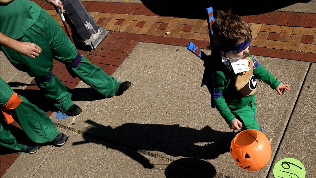 A boy trick-or-treats on Halloween last year in downtown Overland Park, Kan. (AP Photo/Charlie Riedel, File)