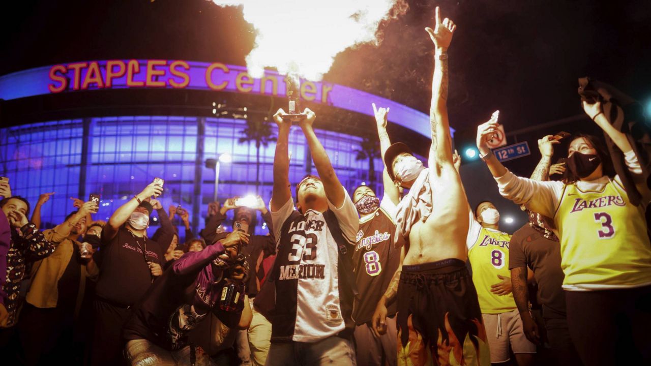 Fans celebrate outside of Staples Center in L.A., after the Lakers defeated the Miami Heat in the NBA Finals to win the championship on Oct. 11, 2020. (AP/Christian Monterrosa)