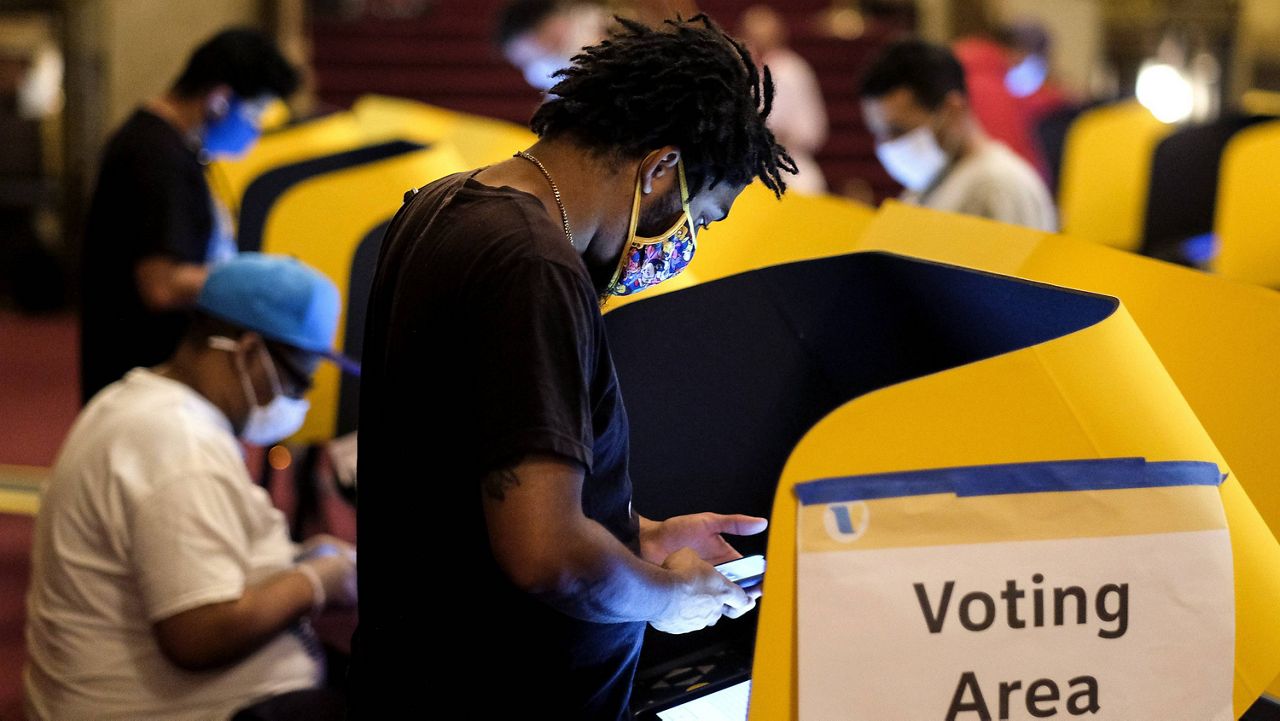 A voter casts his ballot Tuesday at the Pantages Theatre in Hollywood, California. (AP Photo/Ringo H.W. Chiu)