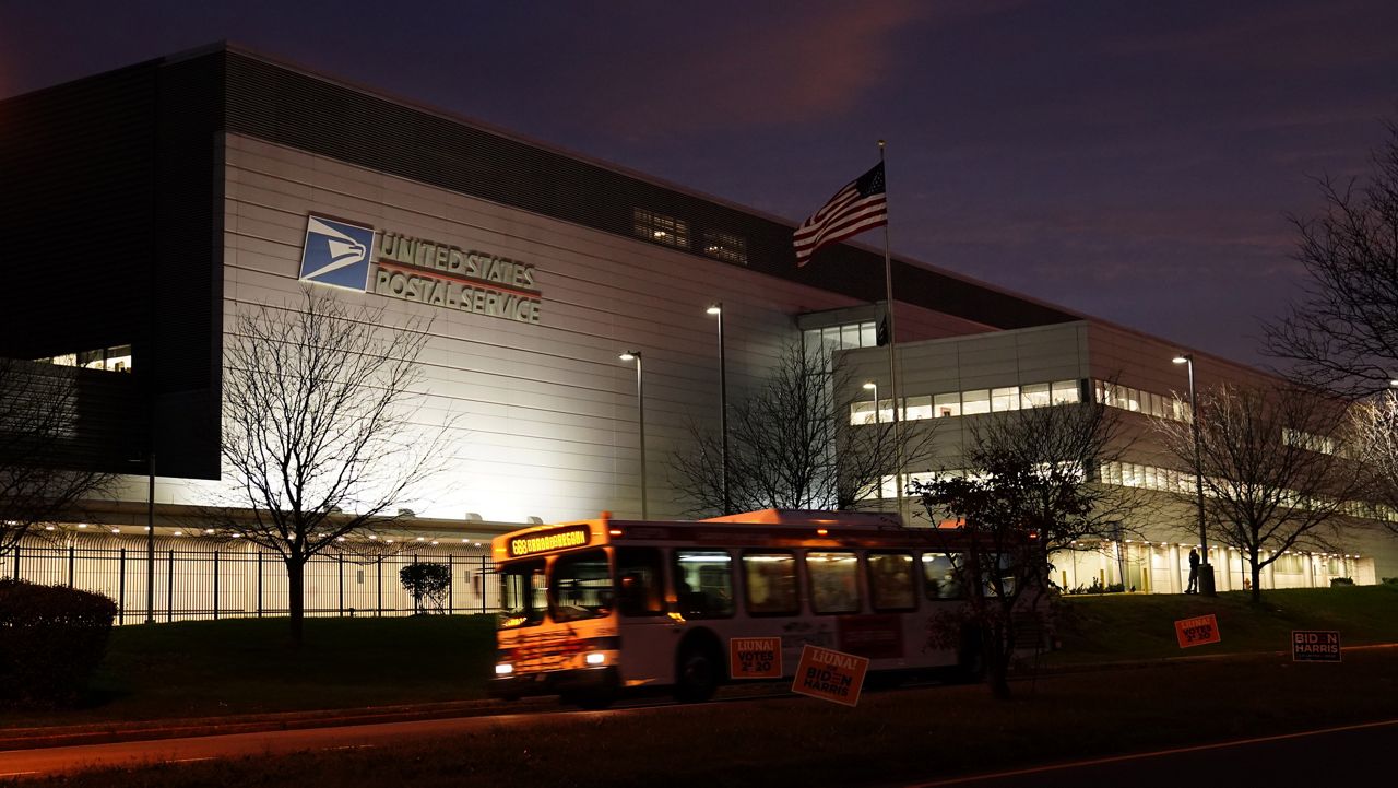 A bus drives past a United States Postal Service facility, Tuesday, Nov. 3, 2020, in Philadelphia. (AP Photo/Matt Slocum)