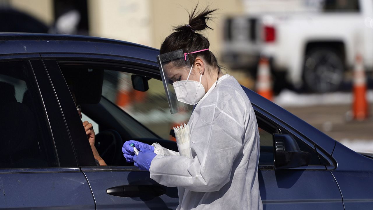 FILE PHOTO - In this Oct. 27, 2020, file photo, a tester prepares to administer a swab test at a drive-in COVID-19 testing site in Federal Heights, Colo. (AP Photo/David Zalubowski, File)