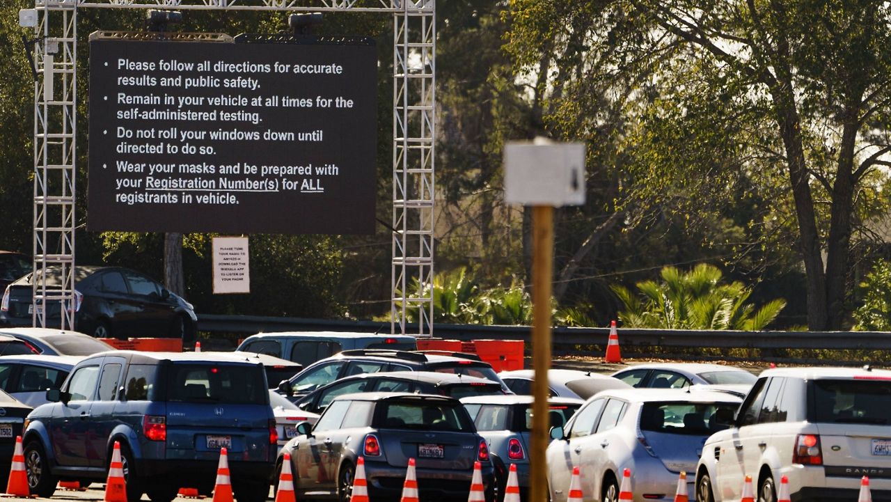 Drivers with an appointment wait in line to get a free of charge COVID-19 virus self-test at Dodger Stadium, with the capacity to test 6,000 Angelenos a day in Los Angeles on Monday, Nov. 9, 2020. (AP Photo/Damian Dovarganes)