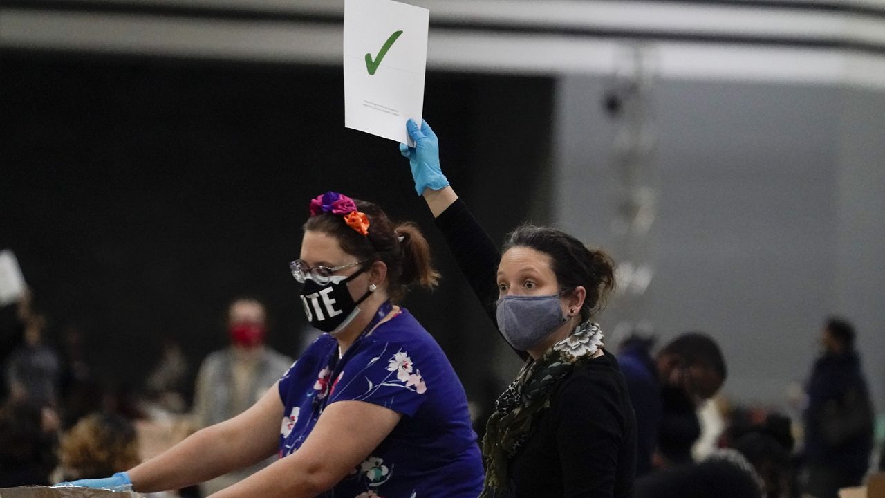 A official holds up a completions sign as they sort ballots during an audit at the Georgia World Congress Center on Saturday, Nov. 14, 2020, in Atlanta. (AP Photo/Brynn Anderson)