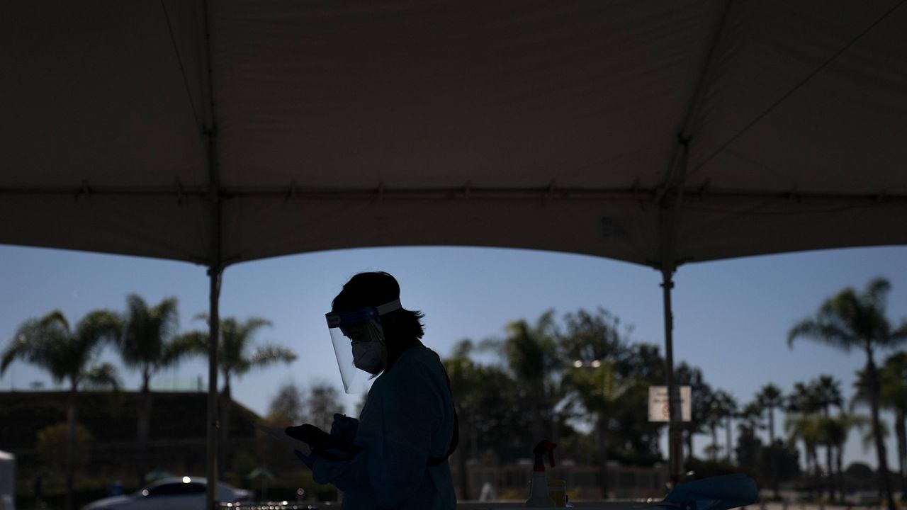 Medical assistant Linh Nguyen works at a COVID-19 testing site set up at the OC Fairgrounds in Costa Mesa, Calif., Monday, Nov. 16, 2020. (AP Photo/Jae C. Hong)