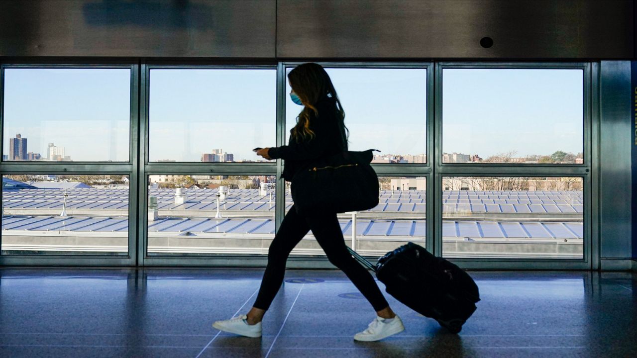A traveler approaches the AirTrain to JKF International Airport Friday, Nov. 20, 2020, in New York. Rising U.S. coronavirus cases, a new round of state lockdowns and public health guidance discouraging trips are dampening enthusiasm for what is usually the biggest travel period of the year.