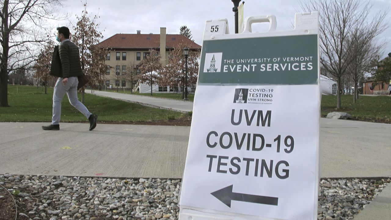 In this Nov. 12, 2020, photo, a University of Vermont student walks toward a tent leading to a COVID-testing site on campus in Burlington, Vt. (AP Photo/Lisa Rathke)