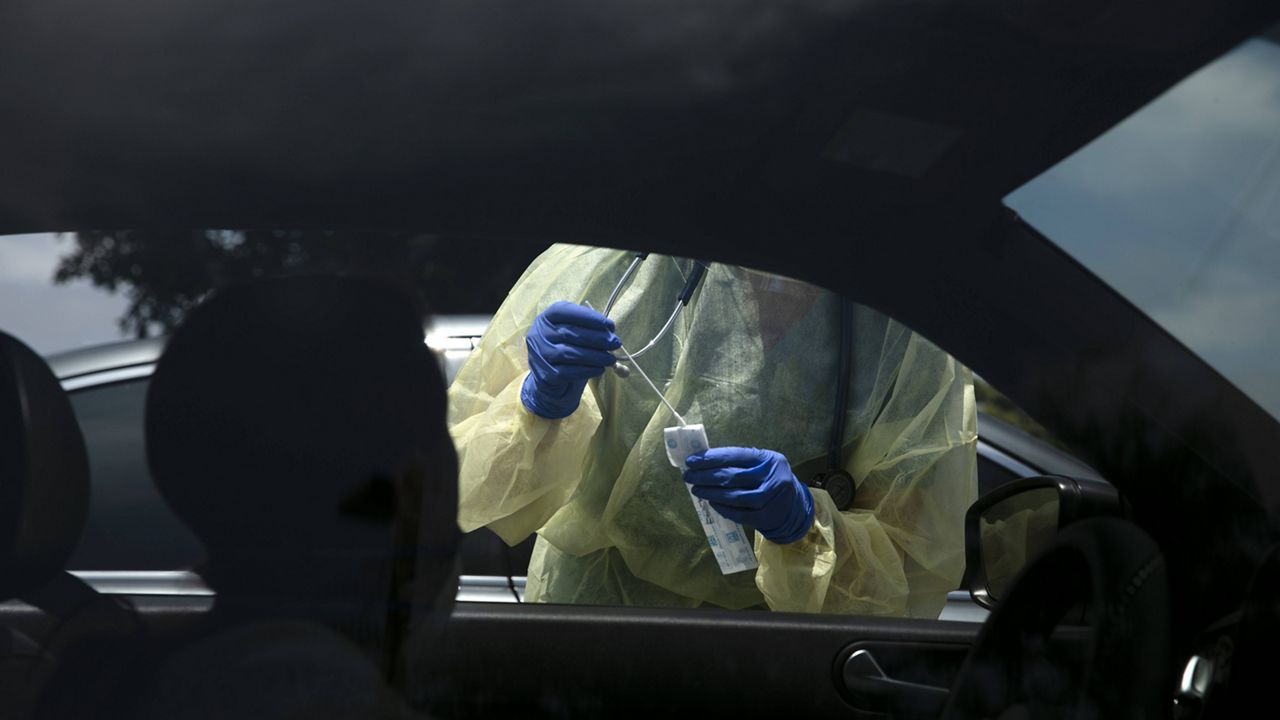 In this June 25, 2020 file photo physician assistant Nicole Kramer prepares to collect a nasal swab sample from a patient for COVID-19 testing at Xpress Urgent Care in Tustin, Calif.  (AP Photo/Jae C. Hong,File)