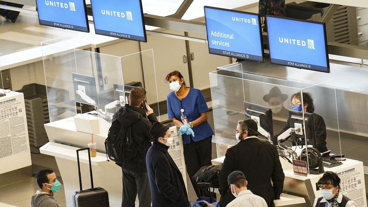 Travelers wait to check-in for their flights at LaGuardia Airport, Wednesday, Nov. 25, 2020, in the Queens borough of New York. (AP Photo/John Minchillo)