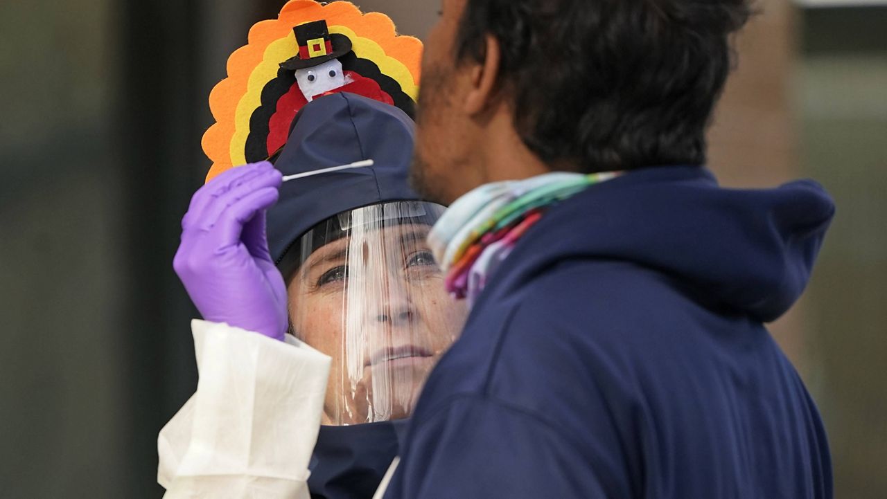 Public health nurse Lee Cherie Booth administers a coronavirus test while dressed as a turkey Wednesday in Salt Lake City. (AP Photo/Rick Bowmer)