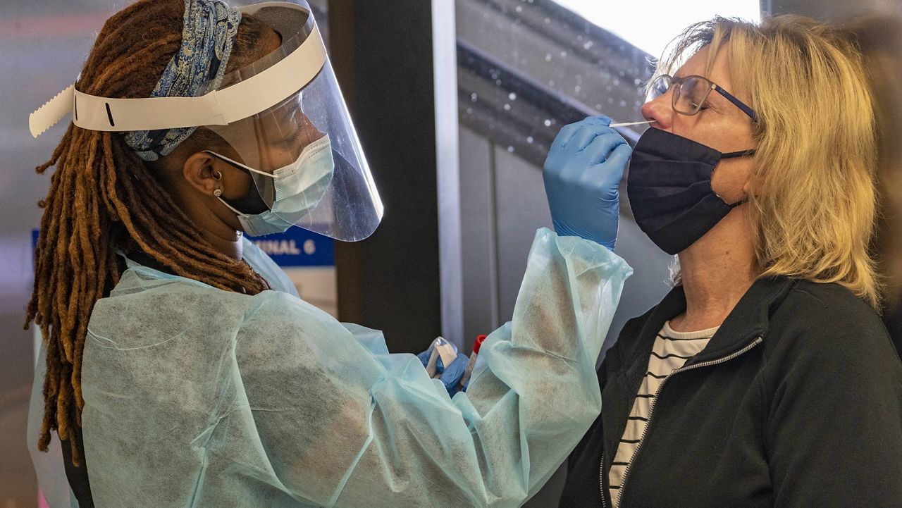 Traveler Patty Siegel, right, gets a COVID-19 nasal swab test before a planned trip to Hawaii at the Los Angeles International Airport on Nov. 25. (AP Photo/Damian Dovarganes) 