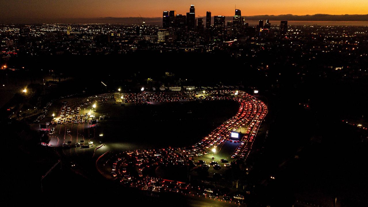 In this Nov 18, 2020, file aerial photo, motorists wait in long lines to take a coronavirus test in a parking lot at Dodger Stadium in Los Angeles. (AP Photo/Ringo H.W. Chiu, File)