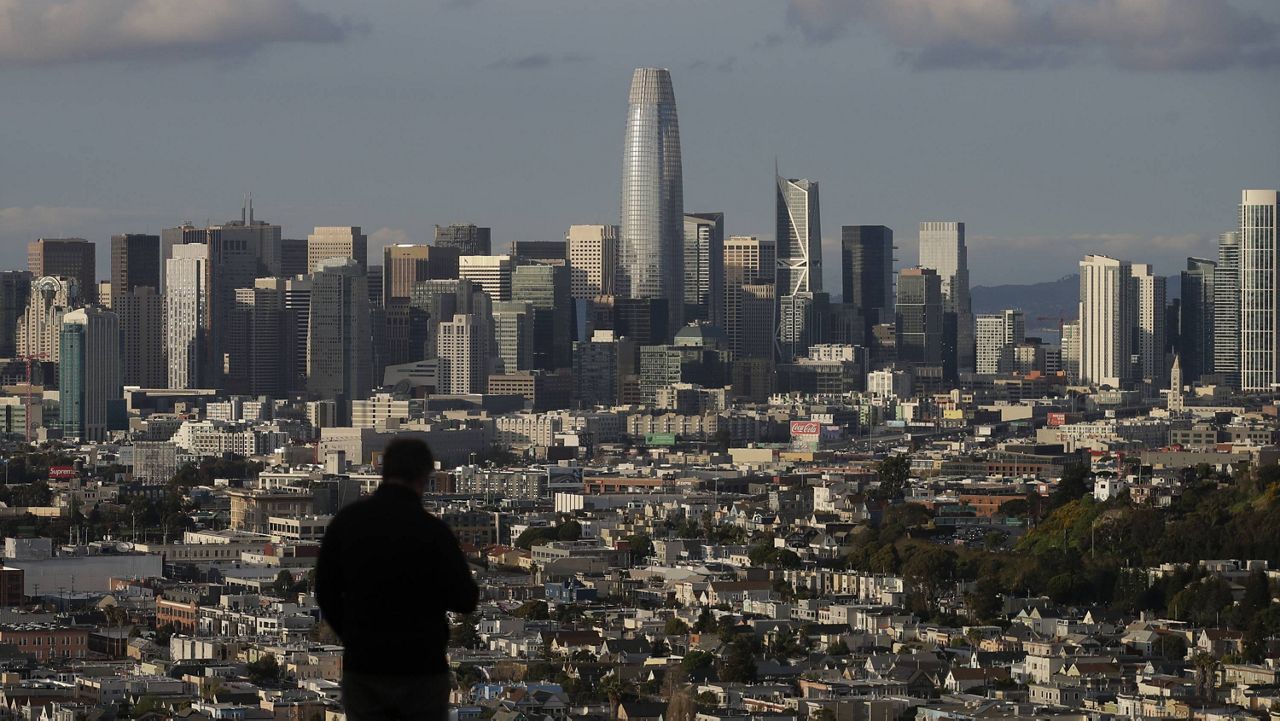 In this March 16, 2020, file photo, a person looks toward the skyline from Bernal Heights Hill in San Francisco. (AP Photo/Jeff Chiu, File)