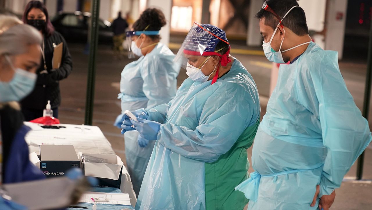 Nurses check on the status of rapid COVID-19 tests at a drive-through testing site in a parking garage in West Nyack, N.Y., Monday, Nov. 30, 2020. (AP Photo/Seth Wenig)