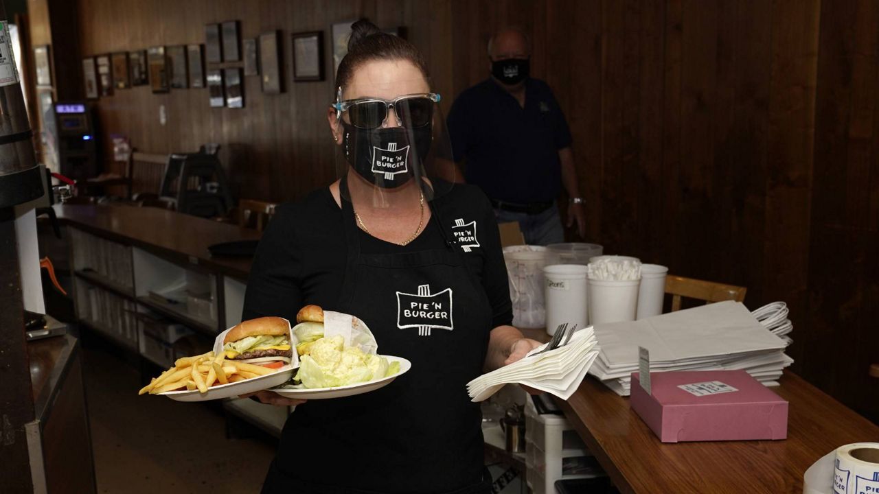 A waitress serves lunch Tuesday, Dec. 1, 2020, at Pie 'N Burger in Pasadena, Calif. (AP/Marcio Jose Sanchez)