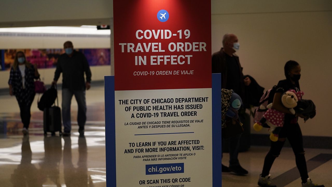 FILE - In this Nov. 24, 2020, file photo, air travelers arriving at Midway Airport in Chicago are reminded of the city's COVID-19 travel orders. (AP Photo/Charles Rex Arbogast, File)