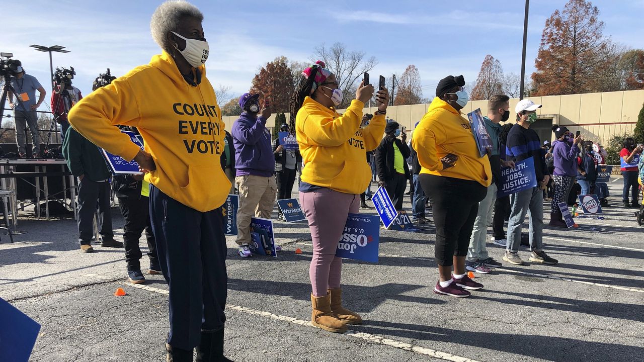 Union members attend a rally, Friday, Dec. 11, 2020, in Atlanta, for election canvassers in Georgia's twin Senate races. (AP Photo/Jeff Amy)